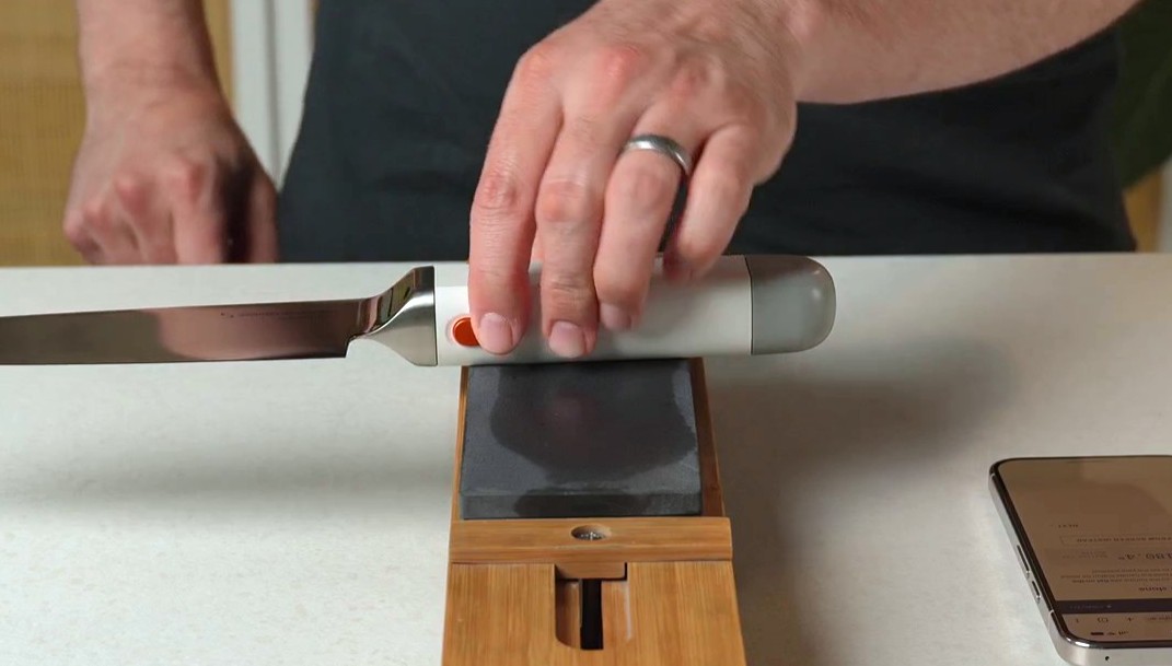 Knife laid on its side with the handle resting flat on the sharpening stone